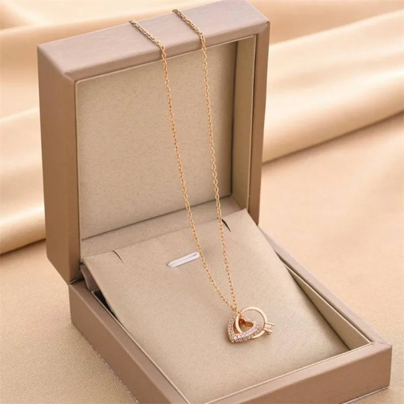 Gold Lovers Embrace Pendant featuring interlinked hearts and diamond detailing, presented in a luxury gift box for special occasions.