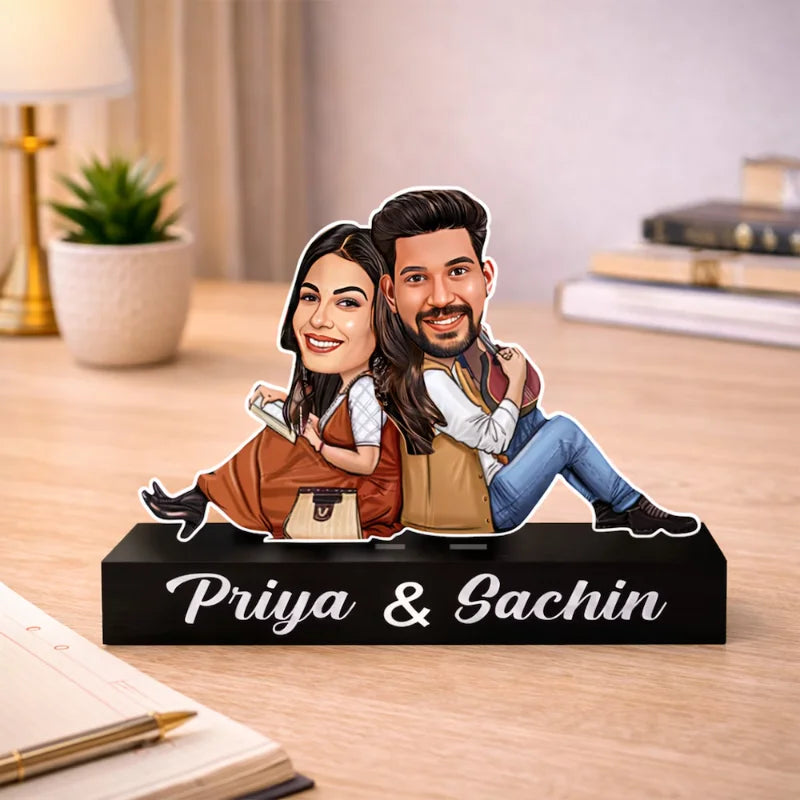 Custom caricature of a couple sitting back-to-back on a nameplate reading Priya & Sachin, crafted from premium MDF and acrylic.