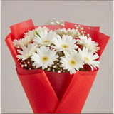 Detailed view of white daisies bouquet with red paper