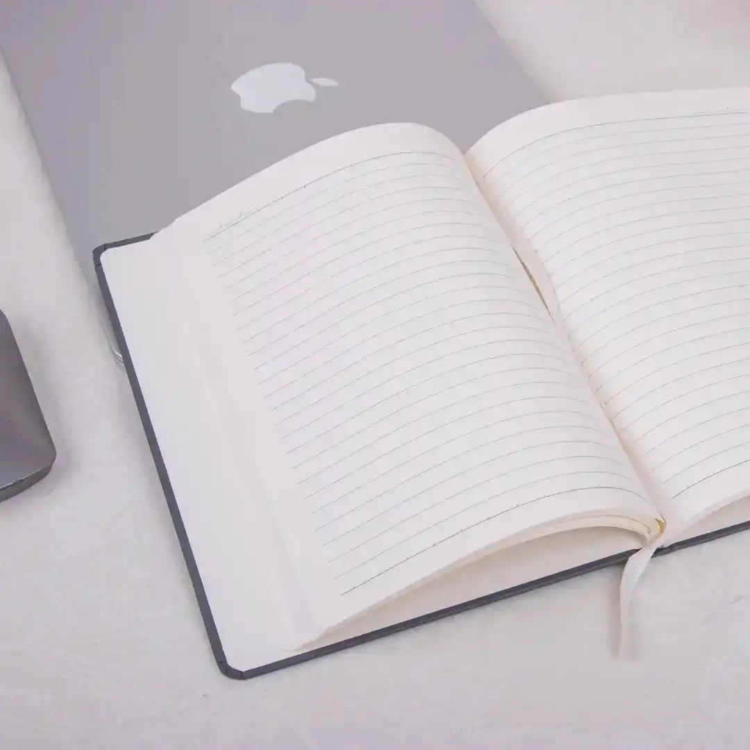 Storyteller’s Journal Personalized Diary with lined pages open on a desk beside a laptop. Ideal for planning workdays and tracking goals.