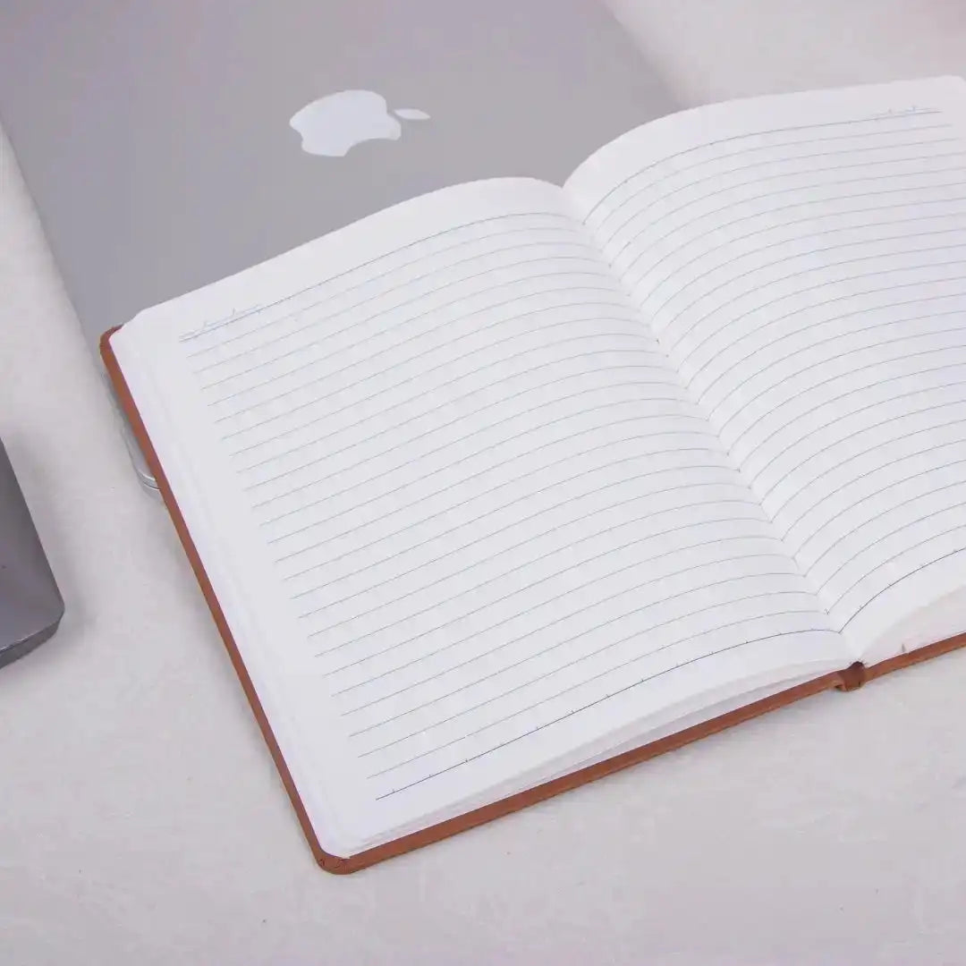 Creativity Thrives Personalized Diary with lined pages open on a desk beside a laptop. Ideal for planning, tracking goals, and daily productivity.