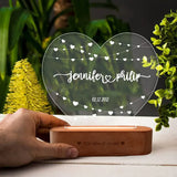 Custom Everlasting Love Wedding Lamp held by hand, showcasing engraved names and date on heart-shaped acrylic with wooden base. Perfect for couples.