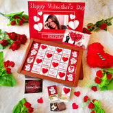 Valentines Day Chocolate Box with 24 assorted flavours, personalized with photo and name, surrounded by red roses and heart-themed decor.