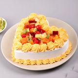 Side angle of Delectable Valentine Heart Cake featuring heart shape, vanilla frosting, and colorful fruit garnish, great for romantic occasions.