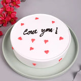 Love You Pineapple Round Cake with white frosting, red heart decorations, and chocolate 'Love you!' text, ideal for Valentine's Day gifting.