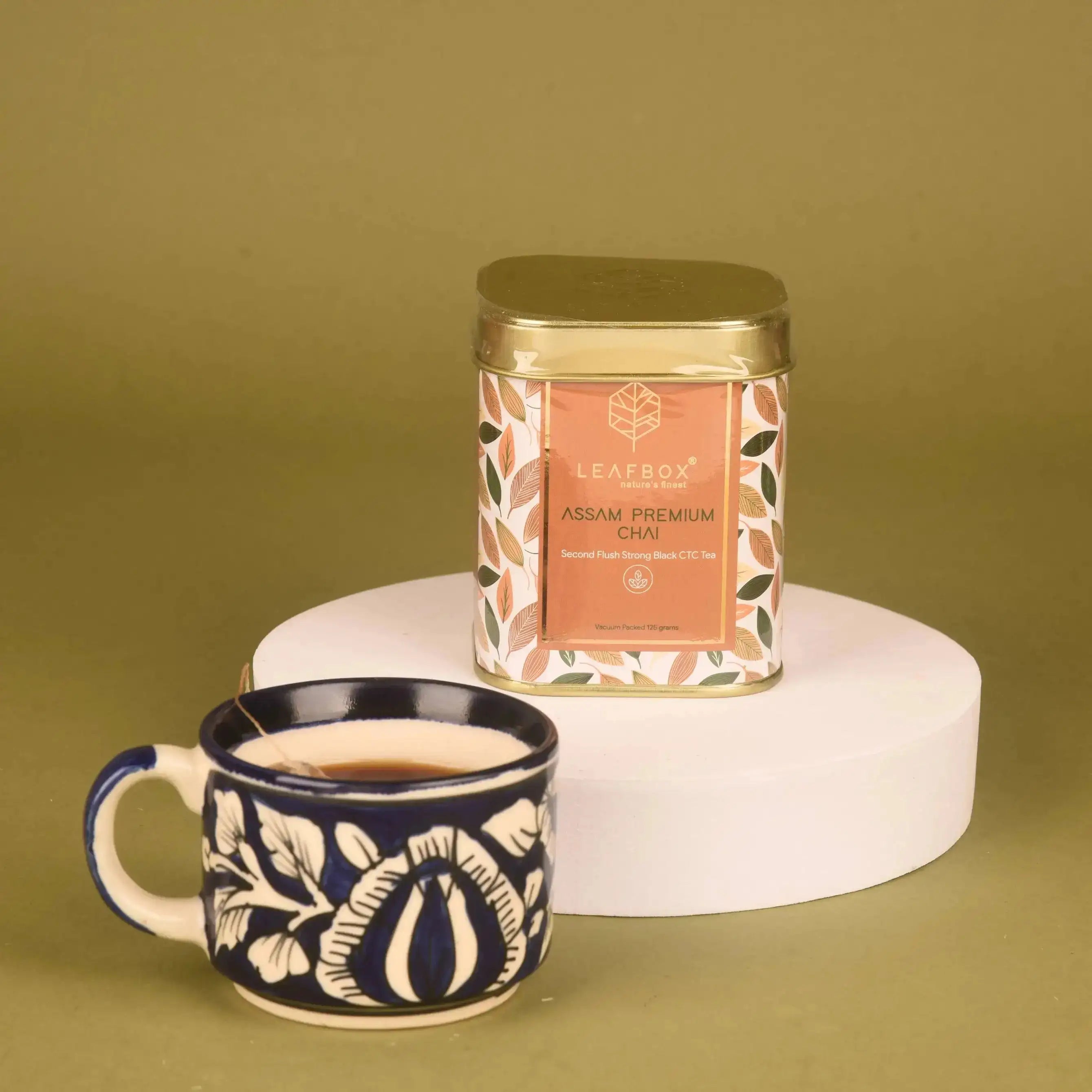Golden Sip Collection features Assam Premium Chai in a designer tin with a ceramic cup, ideal for gourmet Diwali tea gift hampers.