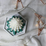 Top view of Christmas Tree Scented Candle surrounded by fairy lights, showcasing its layered pine design for cozy Christmas décor.