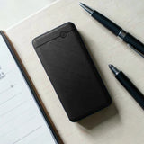 Black power bank with power button on white desk