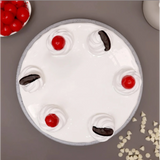 Cake decorated with cherries, chocolate, and whipped cream