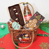 Fusion of Flavors Christmas Hamper with holiday-themed treats including plumcake, granola, masala nuts, and gingerbread chocolate in a festive basket.