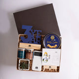 Gift box with calendar, cookie tin, and decorative items on white background.
