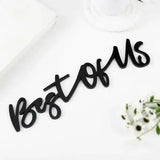 Black acrylic 'Best Of Us' decorative text from the Trio Photo Wall Frame Set, styled on a white surface with flowers and books.