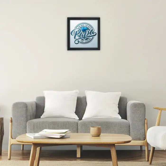 Elegant Father's Day poster frame featuring 'Papa' quote, mounted above a modern grey sofa in a cozy living room setting.