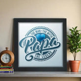 Father's Day poster frame gift with 'The Man. The Myth. The Legend. Papa.' text in blue, displayed on a shelf with a clock and plant.