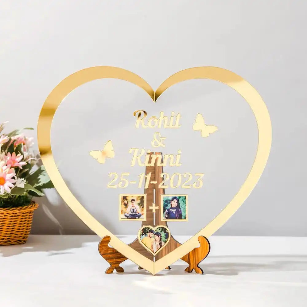Custom Heart Shape Golden Acrylic Frame with engraved names and date, perfect for wedding or anniversary gifts, includes three photo inserts and wooden stand.