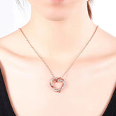 Rose gold heart pendant necklace worn on model, showcasing a minimal and elegant design with embedded crystals, ideal for gifting.