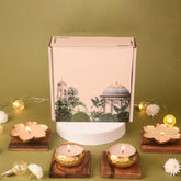 Decorative candles and a box with a botanical design on a green background