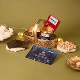 Gifting basket with snacks, chocolates, and a card on a green background
