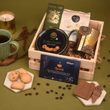 Gift basket with cookies, chocolate, and a candle on a green background