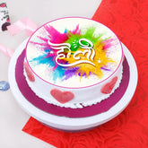 Decorated Holi Festive Cake with white frosting, pink heart accents, colorful splash design, for celebrations
