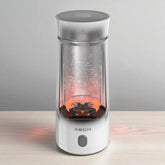 Clear portable blender with red interior on a light wooden surface and gray background
