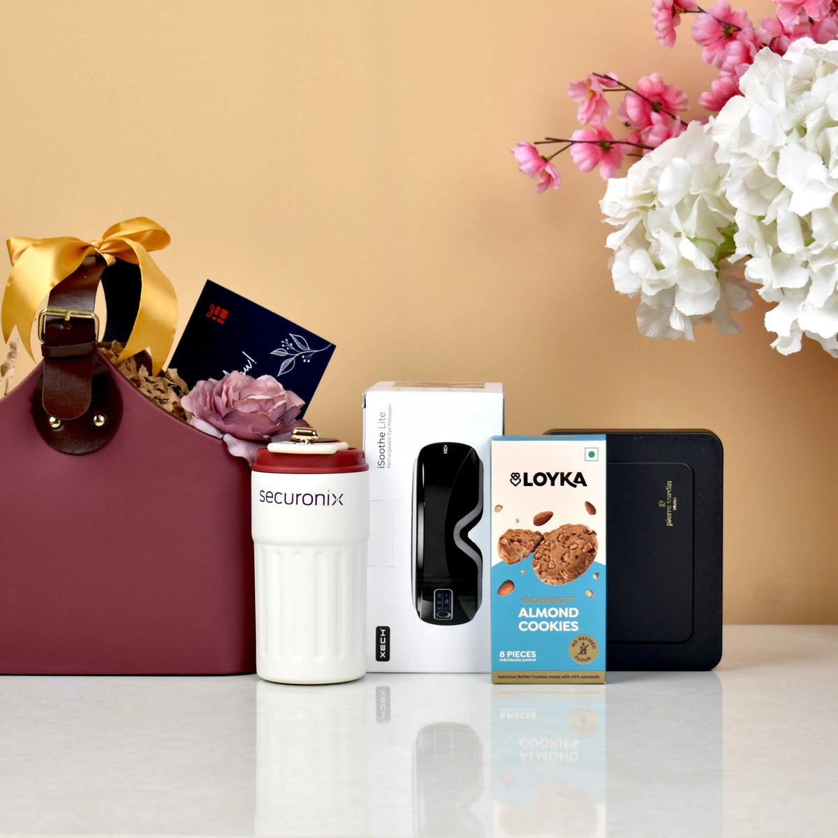 Elite Hamper - Relaxation Gift Set with eye massager, smart mug, almond cookies, luxury pen, and thank you card in a maroon gift bag.