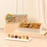 Blissful Bites Gourmet Hamper | Gift Hampers Online featuring an elegant box of assorted premium sweets with floral garnish, ideal for festive gifting.