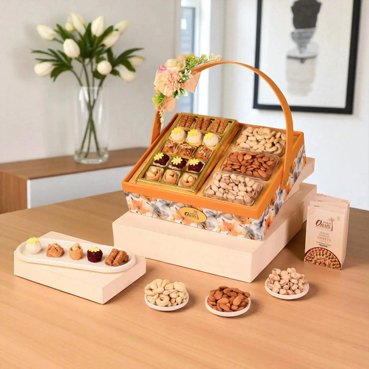 Assorted dry fruits and snacks in a decorative box on a wooden table with flowers in the background.