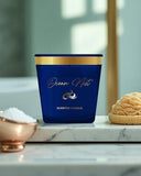 Blue scented candle labeled 'Ocean Mist' on a marble surface with decorative elements.