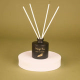 Black diffuser with white sticks on a beige background