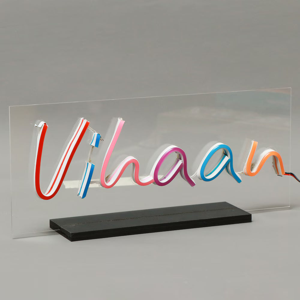 Multicolor LED Neon Sign spelling 'Vihaan' on transparent acrylic with sturdy black base, customizable for home décor or personalized gifts.