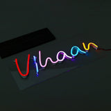 Custom LED Neon Sign with name 'Vihaan' in vibrant red, pink, blue, and yellow tones, perfect for tabletop display in home or office.