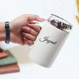 Hand holding a 325ml personalized white ceramic coffee mug with mirror lid, customized with the name 'Jayant'.