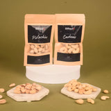 Royal Dryfruit Delight Diwali Gift Hamper showcasing roasted pistachios and cashews in resealable pouches with nuts arranged on marble coasters.