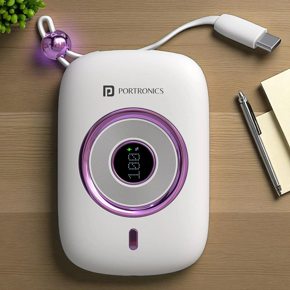 White electronic device with purple accents and 'Portronics' branding on a wooden surface.