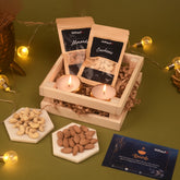 Gift set with almonds, cashews, and candles on a wooden crate with Diwali card.
