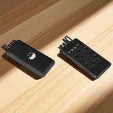 Two black electronic devices on a wooden surface