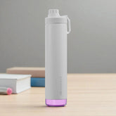 Gray water bottle with purple base on a wooden surface