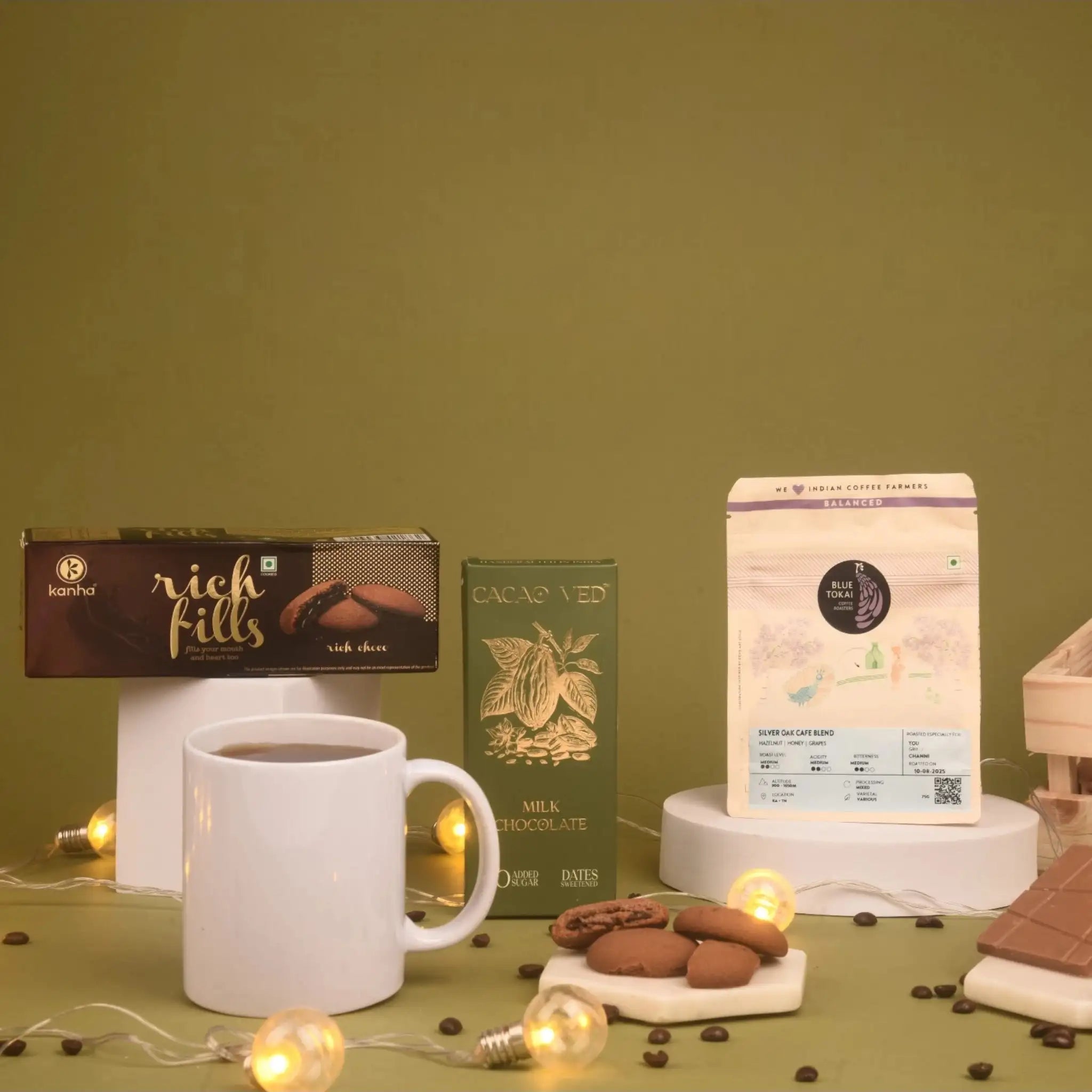The Caffeine Couture Hamper items displayed with coffee, chocolate, cookies, and a white mug, perfect for gourmet festive celebrations.