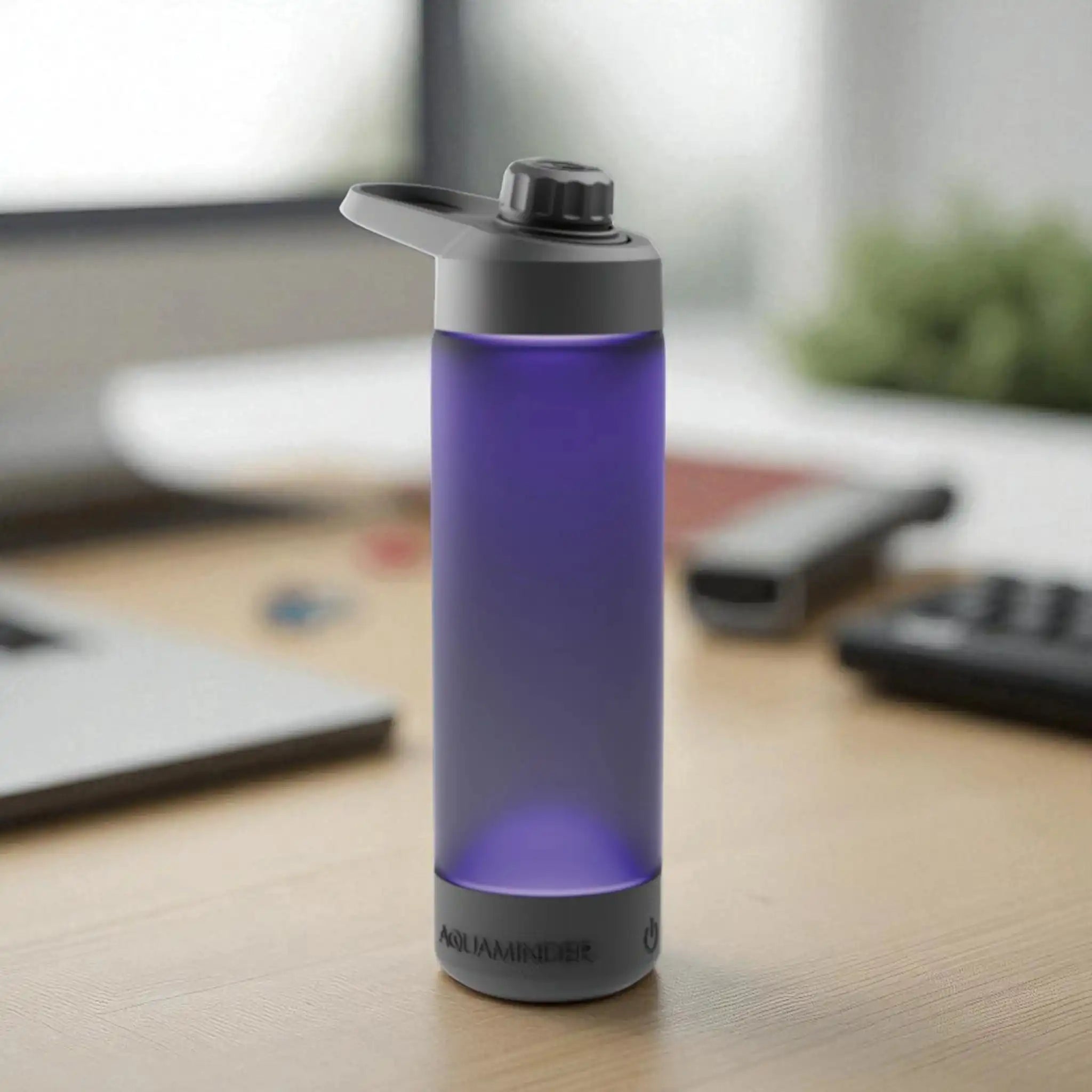 Purple water bottle with black cap on a desk