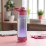 Pink water bottle with purple light on a desk in a bright room
