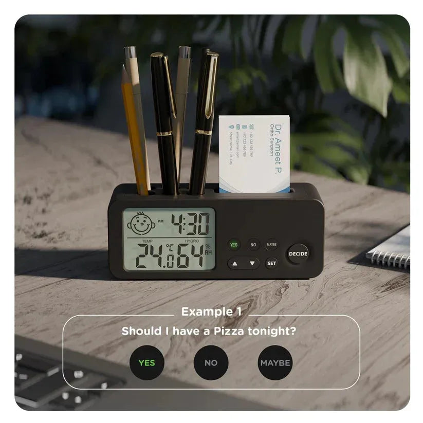 Black digital clock with pen holder and business card slot on a wooden surface