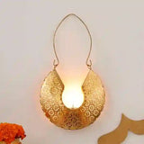 Decorative gold lantern with a lit candle inside on a light background
