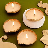 Set of four lit metal diyas from Spark Joy Basket - Diwali Gift Mithai & Diyas, adding festive glow to Diwali decor.