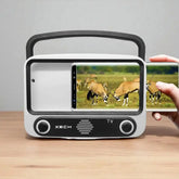 Portable TV with screen displaying antelopes, held by a hand on a wooden surface.