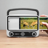 Portable TV with screen displaying antelopes, held by a hand on a wooden surface.