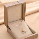 Gold Lovers Embrace Pendant featuring interlinked hearts and diamond detailing, presented in a luxury gift box for special occasions.