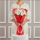 Close-up of white daisies in red wrapping
