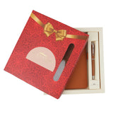 Gift set with red box, brown leather item, and pen on a white background