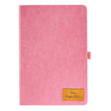 Pink notebook with a gold patch on a white background